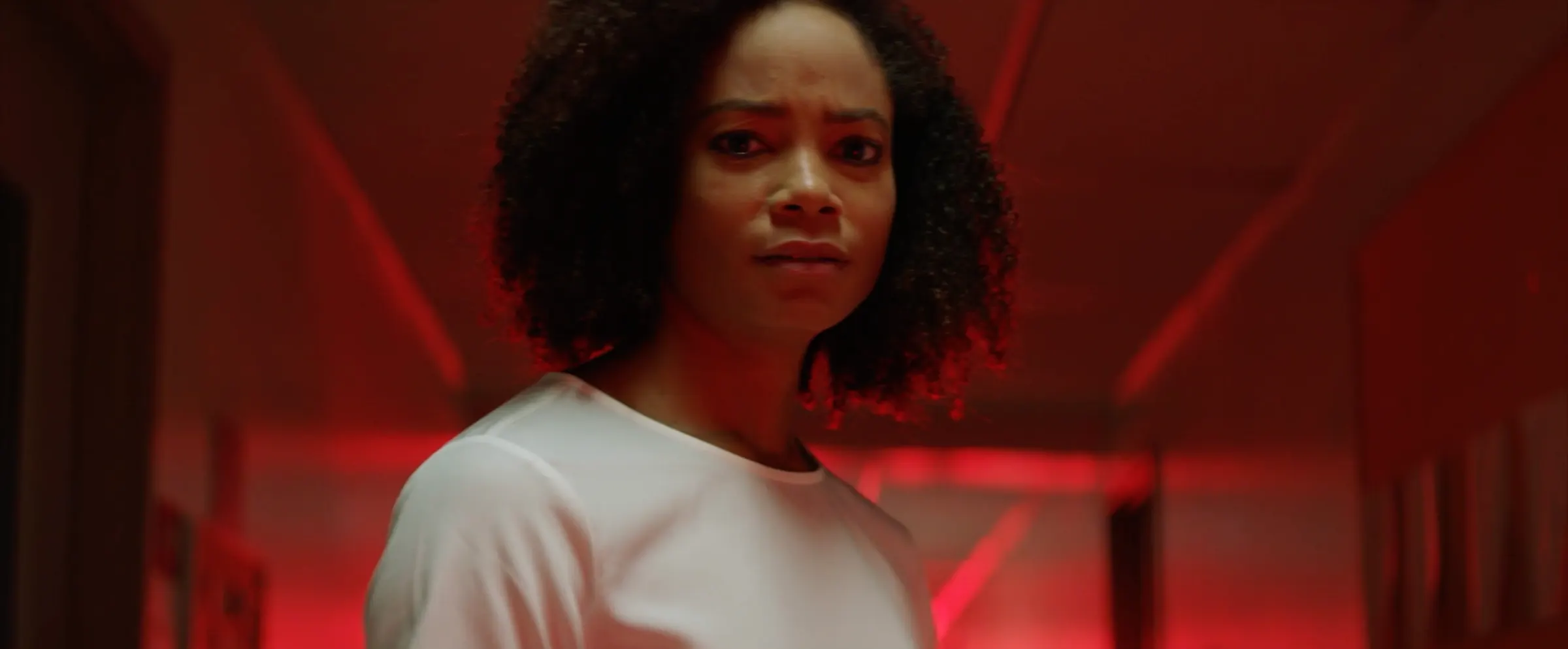 A woman lit in deep red light.